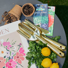 Load image into Gallery viewer, A close up picture of gold gardening tools in an outdoor setting.