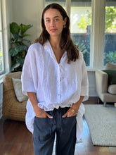 Load image into Gallery viewer, Woman wearing a white blouse and dark pants in a home setting