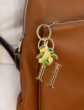 Load image into Gallery viewer, Keychain with &#39;H&#39; and lemon design attached to a brown leather bag.