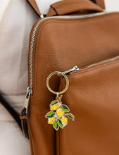 Load image into Gallery viewer, Keychain with lemon design attached to a brown leather bag