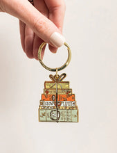 Load image into Gallery viewer, Keychain with stacked boxes design held by a hand on a light background