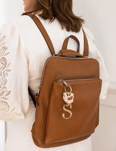 Load image into Gallery viewer, Brown leather backpack with a keychain worn by a person in a white lace top.
