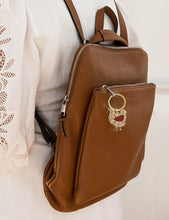 Load image into Gallery viewer, Brown leather backpack with a decorative keychain on a white background